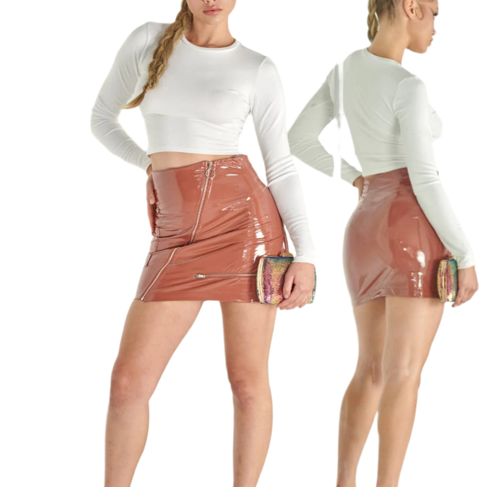 Woman wearing a white long-sleeve top and pink vinyl skirt standing in front of a mirror.