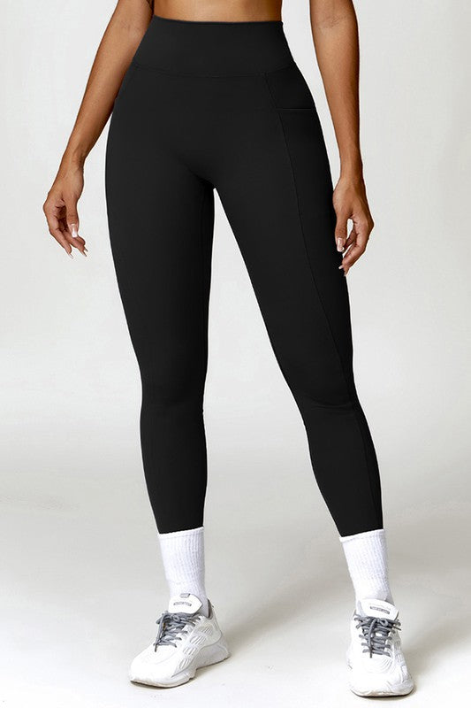 Person wearing black leggings and white sneakers on a plain background