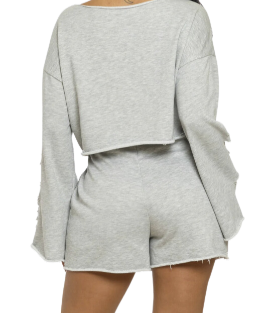 
                  
                    Women's casual streetwear outfit featuring cropped top and high-waisted shorts with ripped details.

Ropa urbana moderna con shorts deshilachados y blusa con parches
                  
                