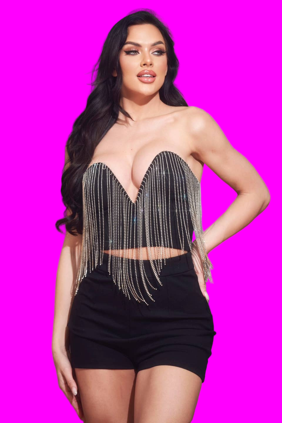 Woman wearing a black fringe top against a gray background