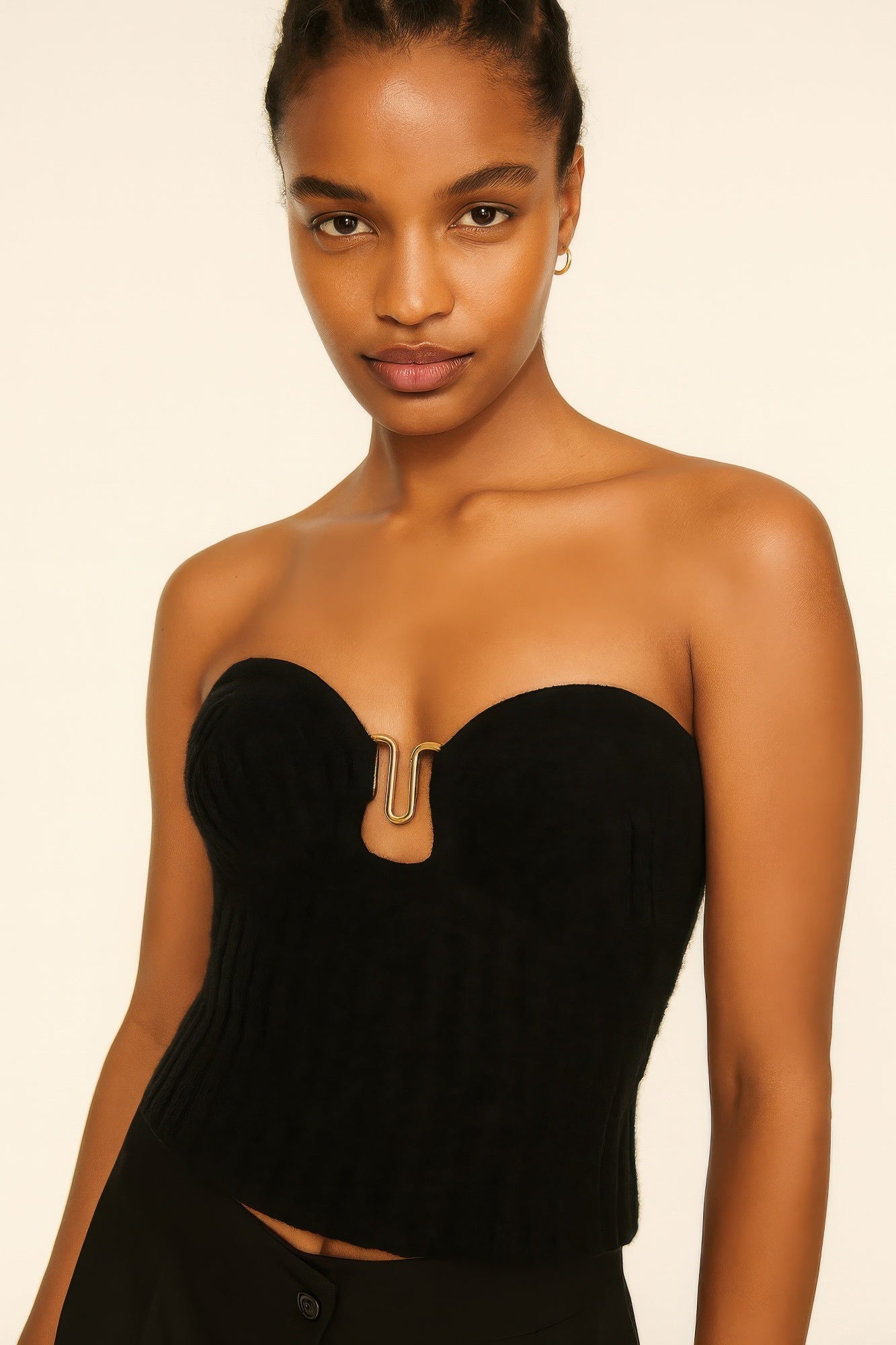 Model wearing a black strapless knit top, showing a close-up of the gold hardware detail at the center of the sweetheart neckline. Denver, Colorado USA.