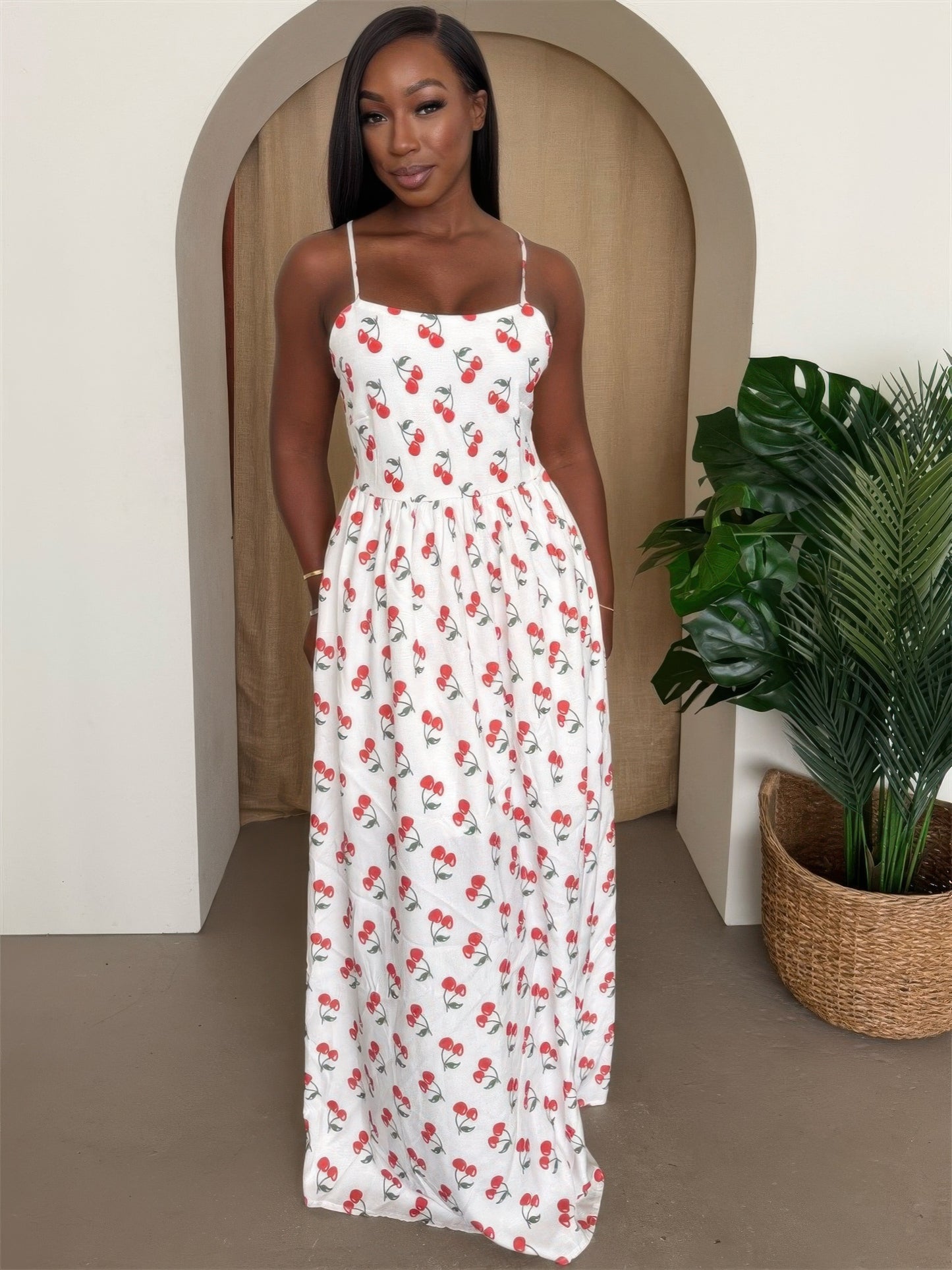 Model wearing a white print maxi dress with thin straps, perfect for summer and holiday wear. The flowy design gives a feminine, playful vibe ideal for brunch, vacation, or festive gatherings. Available for pickup or shipping from Denver, Colorado.

Modelo con vestido largo blanco de tirantes delgados y estampado de cerezas, ideal para el verano y la temporada festiva. En denver colorado y hacemos envios.