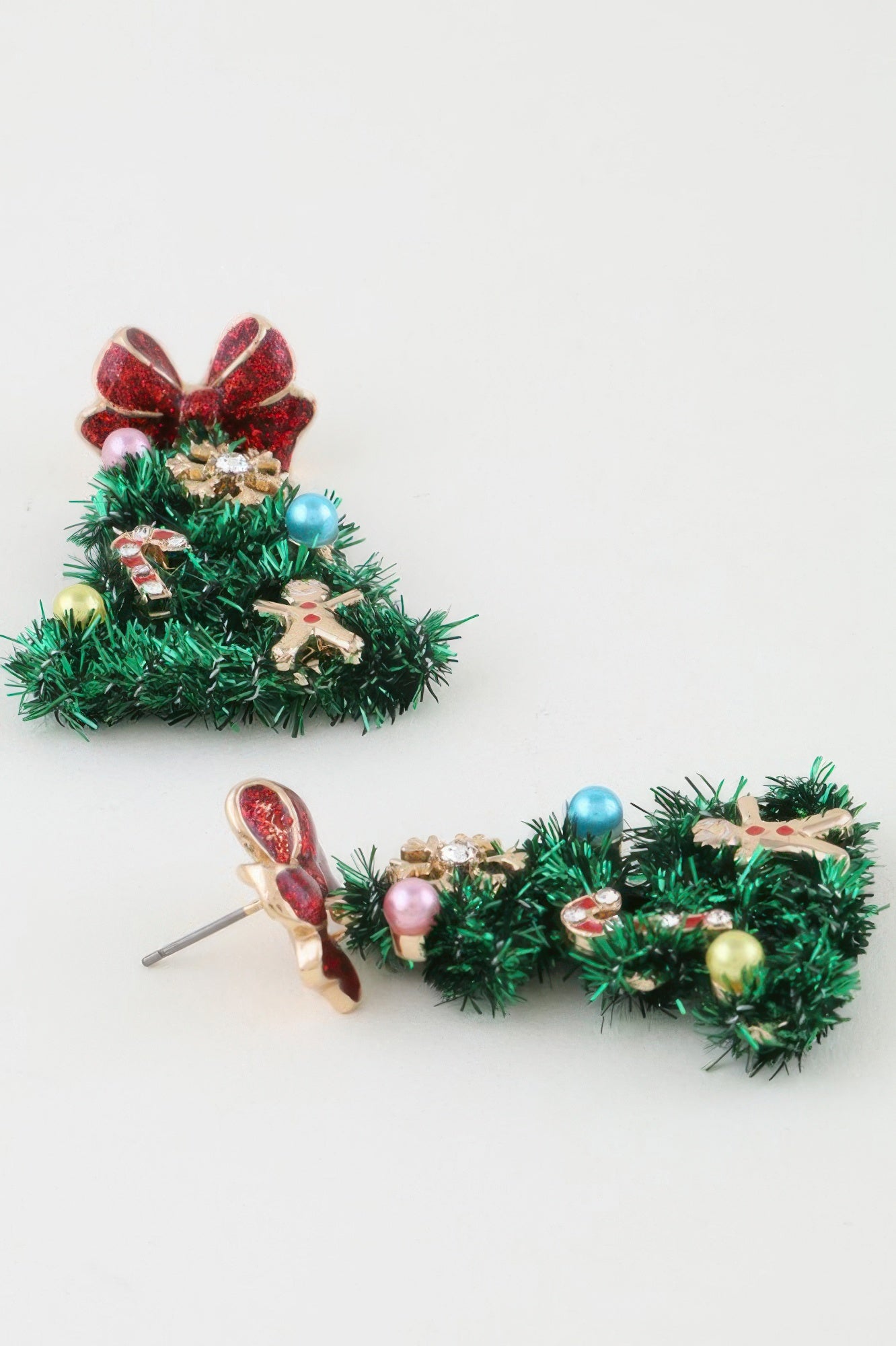 Close-up of the Christmas tree drop earrings, showing the post backing on the red glitter bow and the green tinsel texture of the tree. Available from CO-Wear in Denver, Colorado USA.