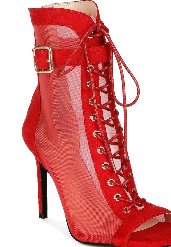 A close-up side view of the red mesh and microfiber stiletto bootie, emphasizing the intricate red lace-up front with gold eyelets, the sheer mesh panel, and the adjustable ankle strap with a gold buckle. Available from CO-Wear in Denver, Colorado USA.