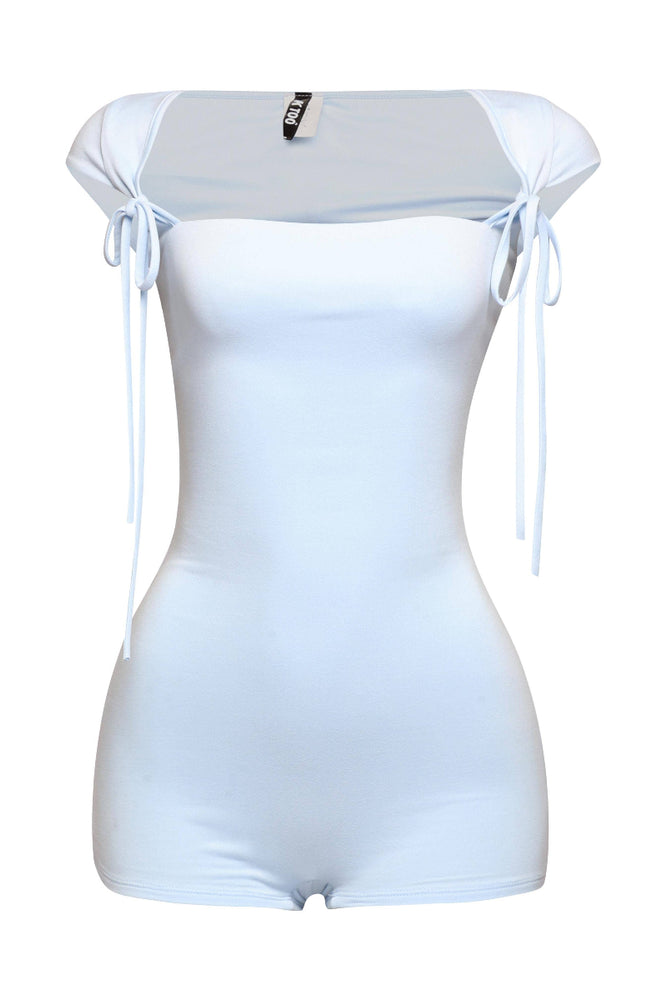 
                  
                    A light-colored short romper is displayed on a mannequin. It features a square neckline and short sleeves with tie details at the shoulders. The romper is fitted and designed to hug the body. The background is white.
                  
                