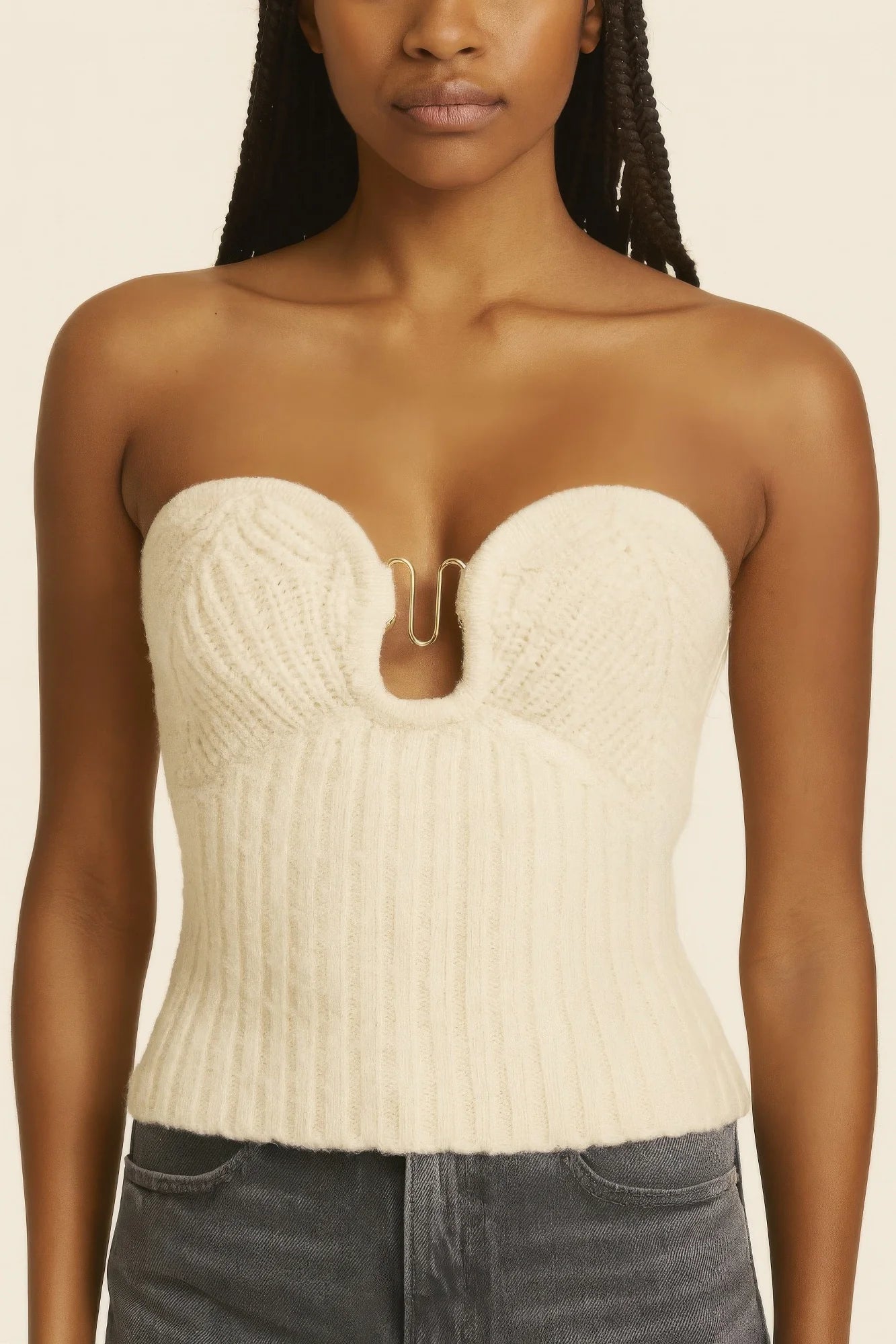 Torso close-up of a model wearing a cream strapless ribbed knit top with a gold clasp detail at the center front. Denver, Colorado USA.