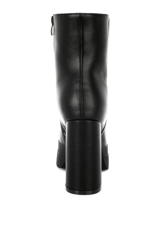 A direct rear view of the black faux leather chunky platform boot, highlighting the seamless back shaft and the tall, solid cylindrical block heel. Available from CO-Wear in Denver, Colorado USA.