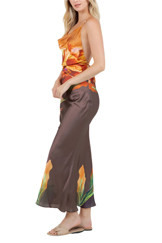 
                  
                    Woman wearing a floral one-shoulder top and brown pants on a white background
                  
                