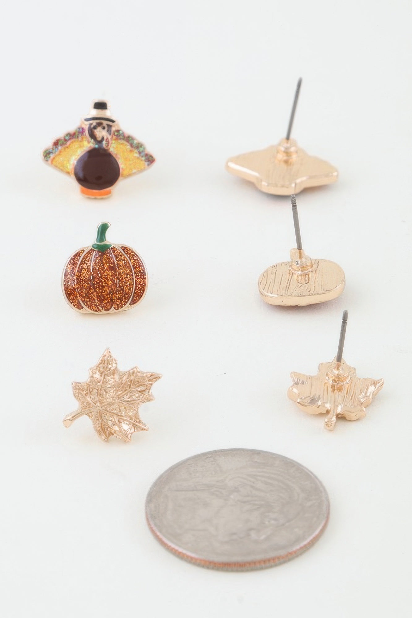 Close-up showing the reverse side of the fall stud earrings next to a US quarter for size reference, highlighting the post backs. Available from CO-Wear in Denver, Colorado USA.