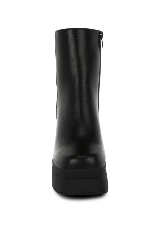 A direct front view of the black faux leather chunky platform boot, highlighting the tall shaft, the prominent platform sole, and the stylish square toe design. Available from CO-Wear in Denver, Colorado USA.