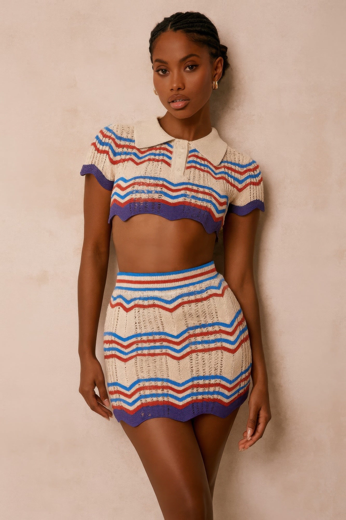 Model wearing a multicolor Zig Zag Crochet Two Piece Set consisting of a short-sleeve polo crop top and a matching mini skirt with red, blue, and purple zig-zag stripes. Denver, Colorado USA.