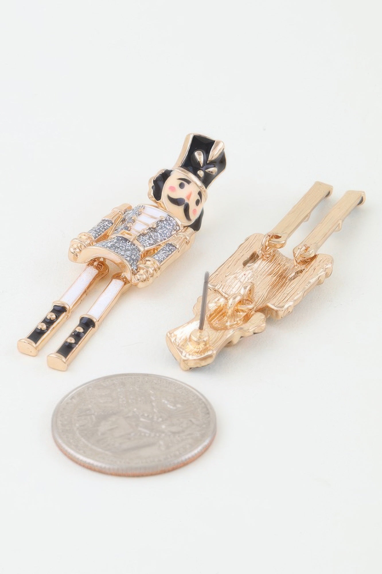 Close-up showing the size of the Glitter Nutcracker Earrings next to a US quarter, detailing the front glitter and the back post closure. Available from CO-Wear in Denver, Colorado USA.