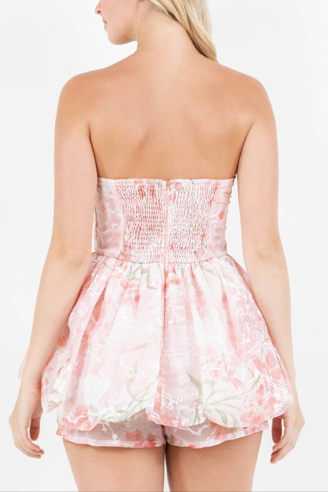 
                  
                    Woman wearing a strapless floral dress on a white background
                  
                
