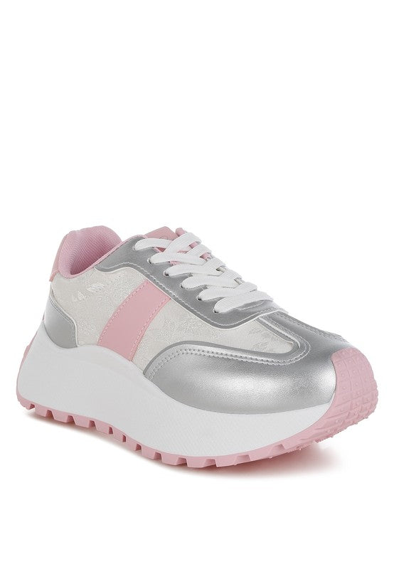 A side profile of a women's chunky sneaker featuring a white patterned panel, metallic silver details, pink accents, and a large white platform sole with pink tread. Available from CO-Wear in Denver, Colorado USA.