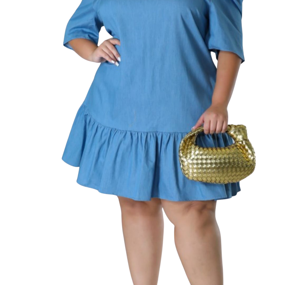 This plus size denim shirt dress features puff sleeves, a pointed collar, and a ruffled hem. Styled with a metallic handbag for a chic, casual look. Este vestido camisero de mezclilla para talla grande tiene mangas abullonadas, cuello en punta y dobladillo con volante. Combinado con una bolsa metálica para un look casual y elegante.