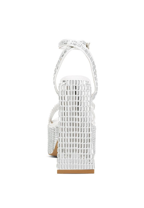 A straight rear view of the white platform sandal, focusing on the high, wide block heel that is entirely covered in square mirror embellishments. Available from CO-Wear in Denver, Colorado USA.