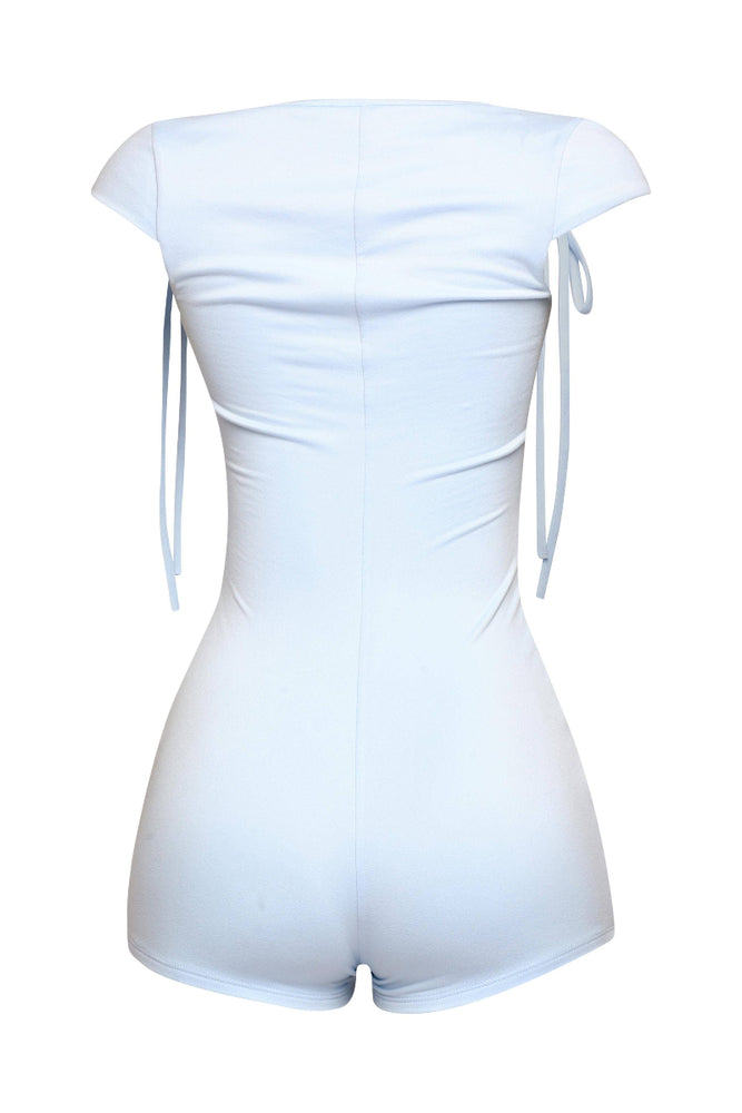 
                  
                    The back view of a light-colored short romper is displayed on a mannequin. It features a square neckline and short sleeves with tie details at the shoulders. The romper is fitted and designed to hug the body. The background is white.
                  
                