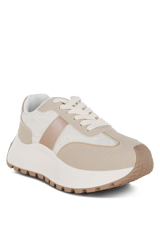 A side angled view of the beige and neutral 'Squeaker' chunky lace-up sneaker, featuring a thick, layered midsole, durable tread, and a textile and suede upper with a rose gold accent stripe. Available from CO-Wear in Denver, Colorado USA.