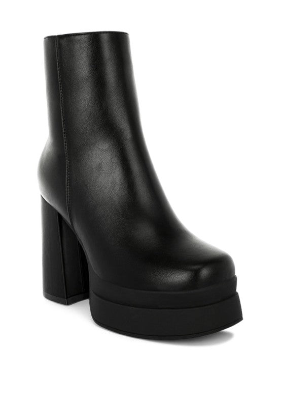 A side view of the black faux leather zip-up boot featuring a tall, stacked platform sole and a substantial chunky block heel. The boot has a clean, smooth shaft. Available from CO-Wear in Denver, Colorado USA.