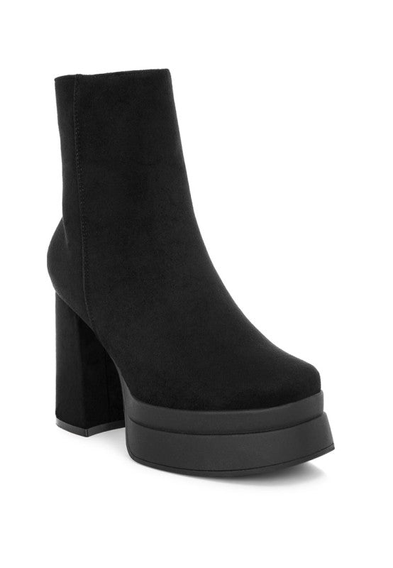 A side profile of a black microfiber ankle boot, featuring a towering chunky platform sole and a substantial, matching covered block heel. Available from CO-Wear in Denver, Colorado USA.