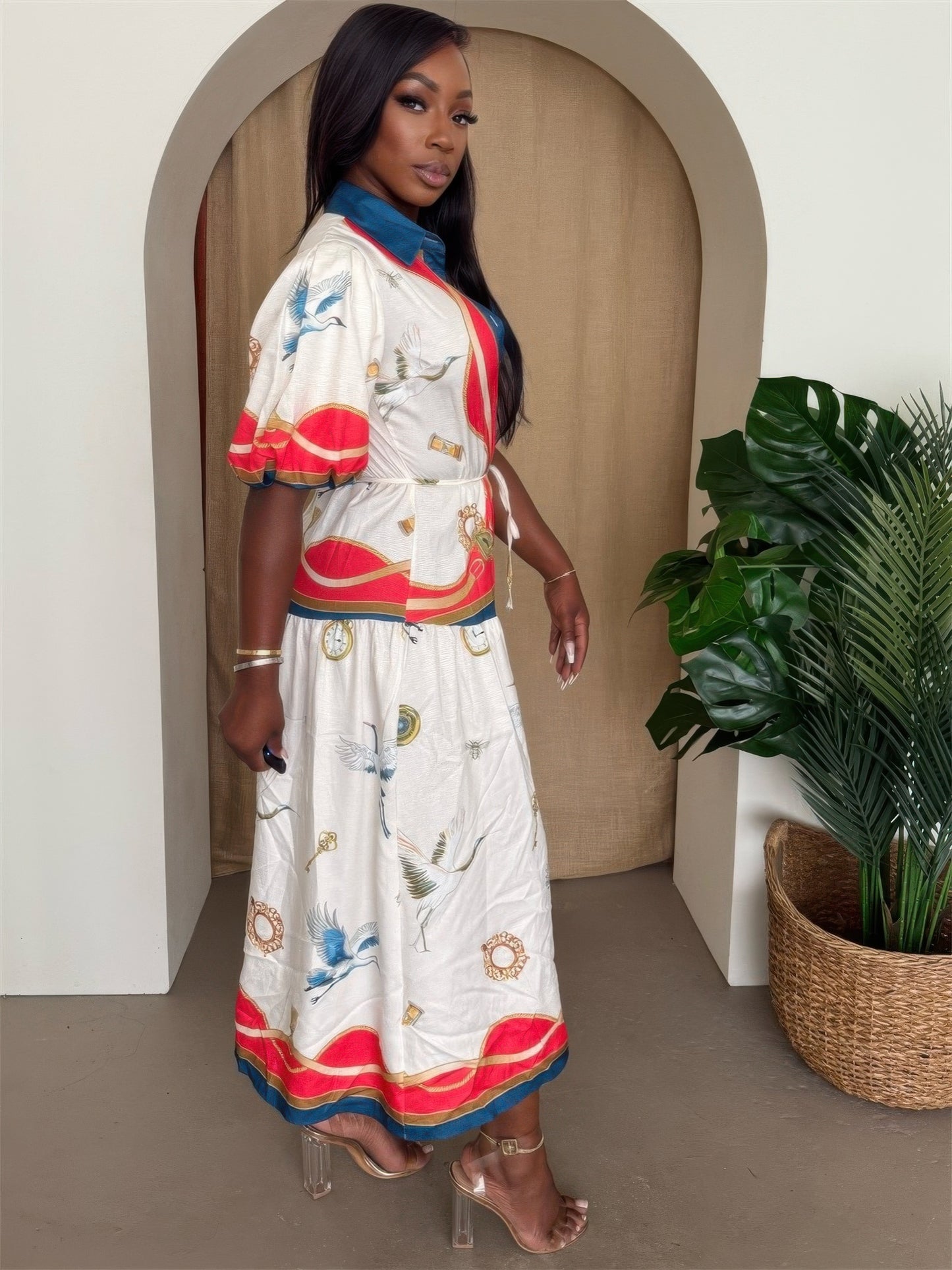 Side-profile view of a model wearing the Ivory Multi Crane and Nautical Print Midi Dress, showcasing the waist tie and short puff sleeves. Available from CO-Wear in Denver, Colorado USA.