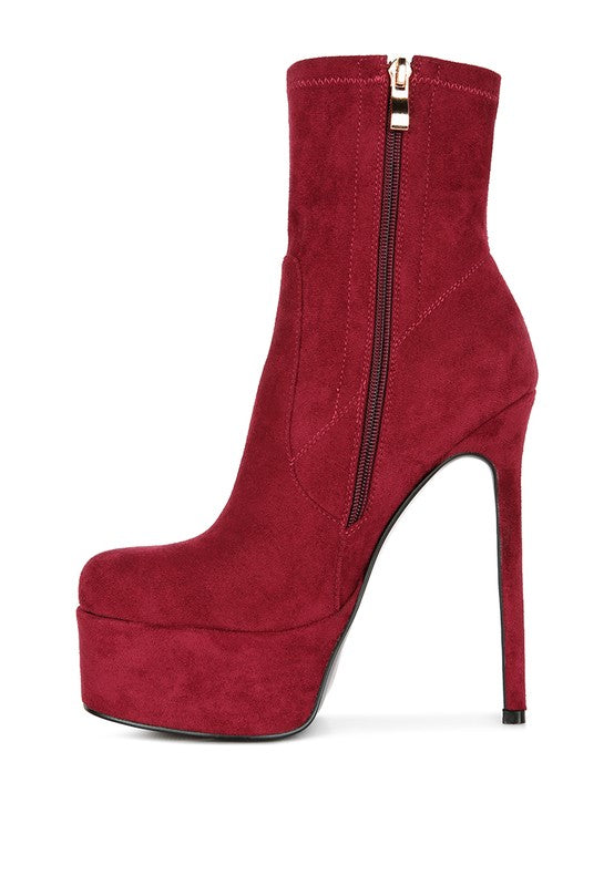 A side profile of a red microfiber ankle boot, emphasizing the extremely high stiletto heel, the thick platform, and the full-length gold zipper closure on the side. This boot is available from CO-Wear in Denver, Colorado USA.