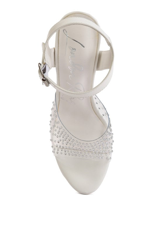A top-down view of the white 'First Date' sandal, showing the ankle strap and the clear toe strap studded with rhinestones over the high platform sole. Available from CO-Wear in Denver, Colorado USA.