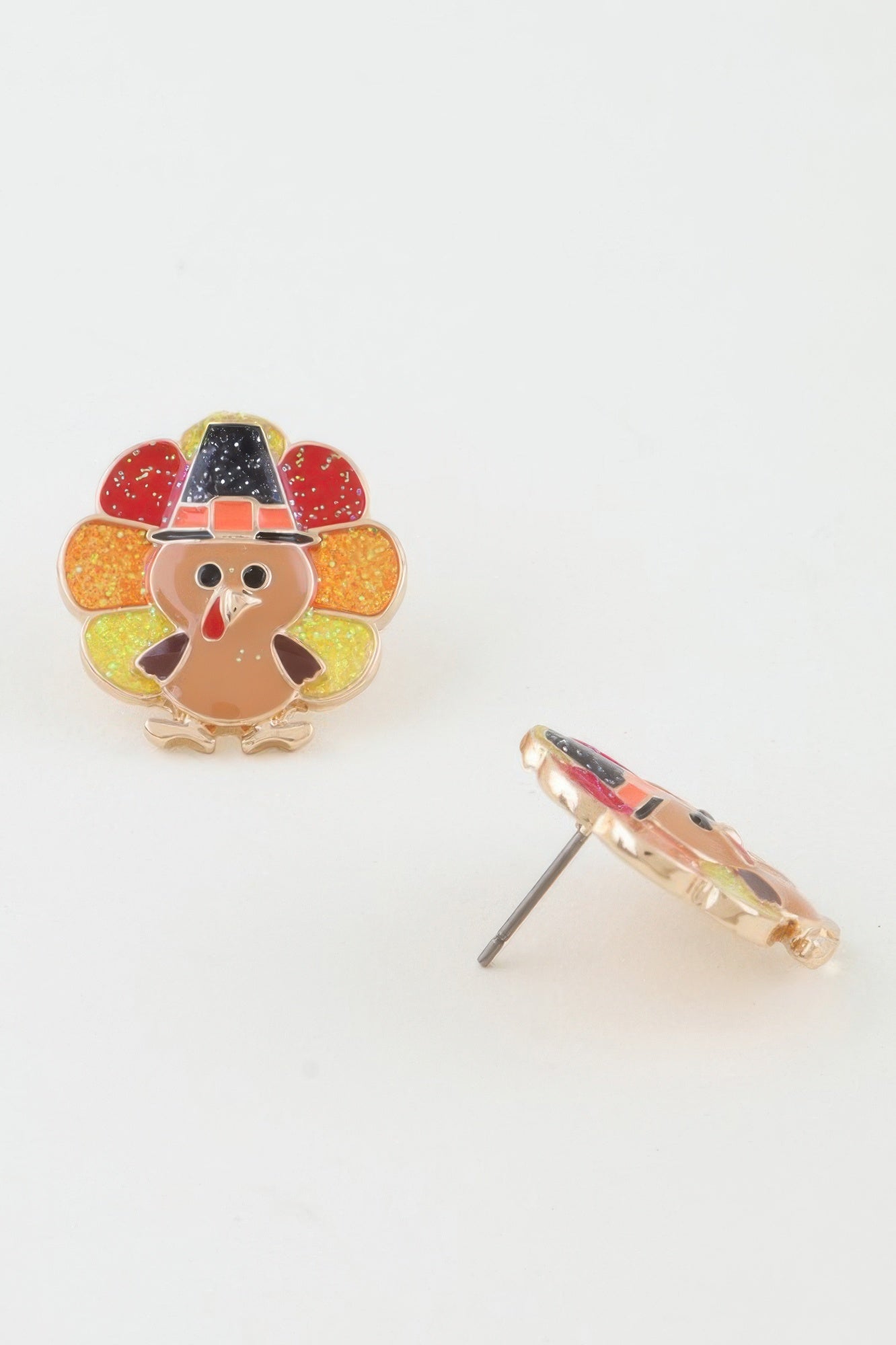 Close-up showing the front of one glitter turkey stud earring and the side view of the second, clearly displaying the post backing. Available from CO-Wear in Denver, Colorado USA.