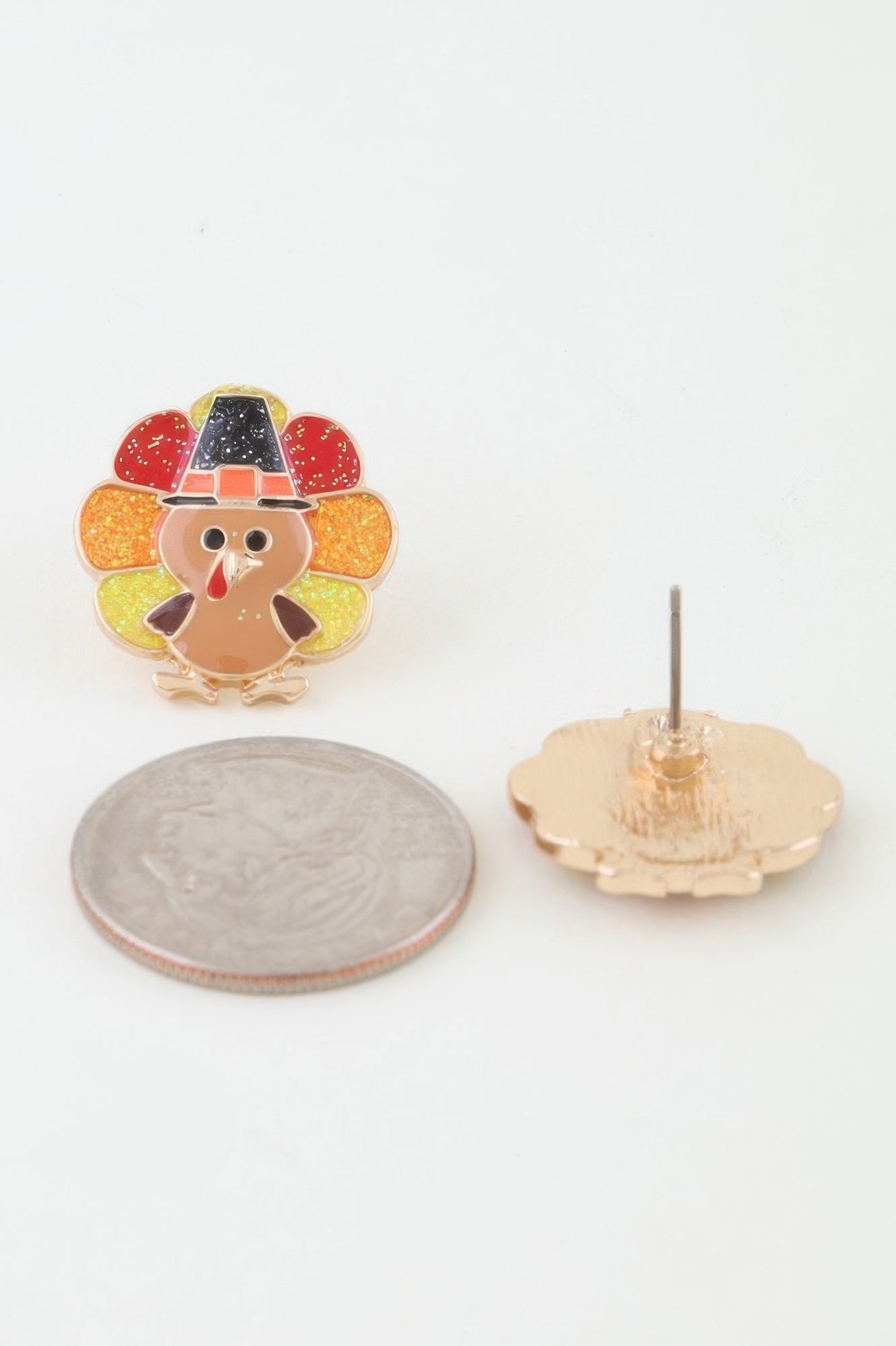 A close-up showing the size of the Glitter Thanksgiving Turkey Stud Earring next to a US quarter, with a second earring showing the back post. Available from CO-Wear in Denver, Colorado USA.