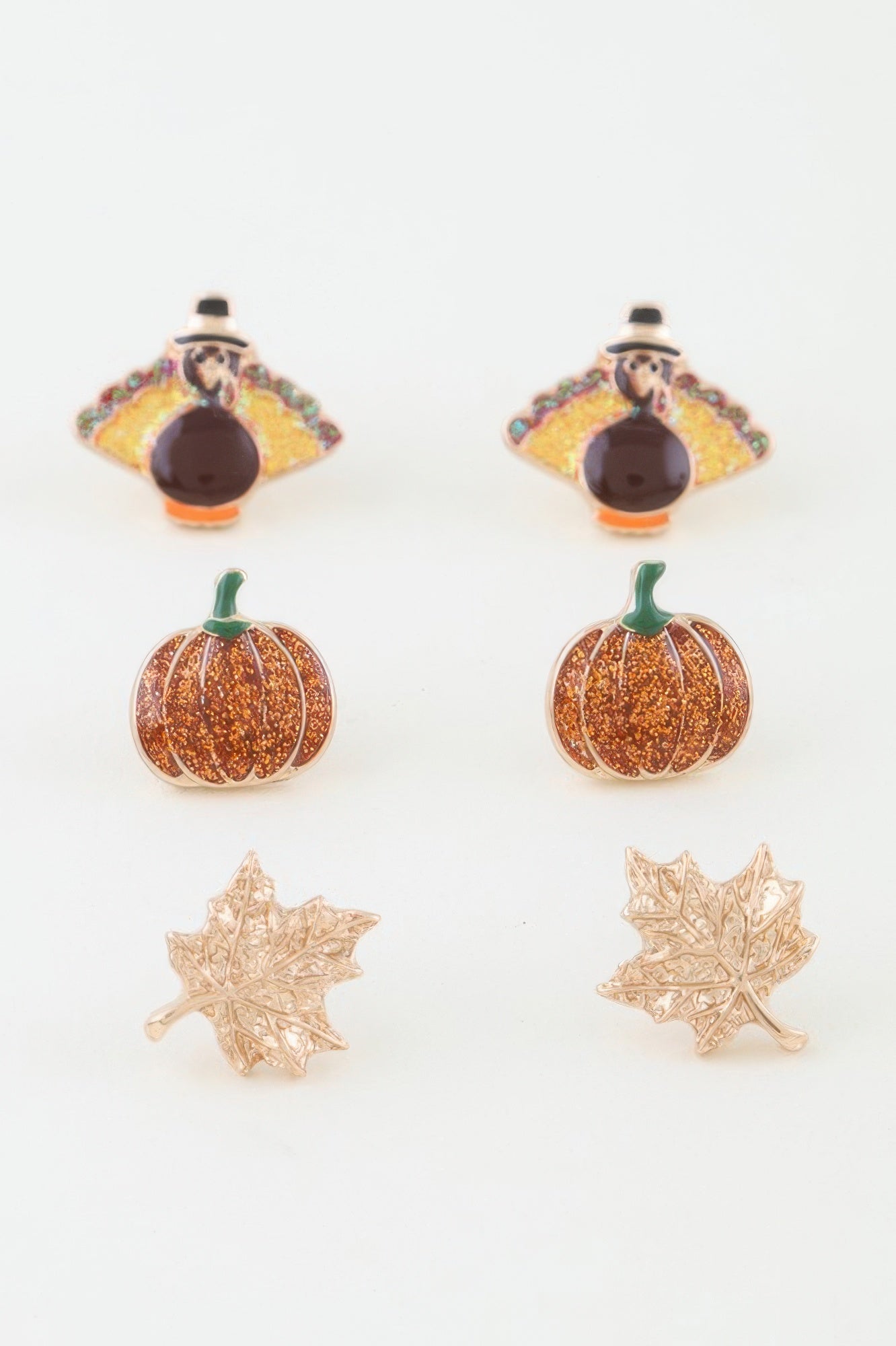 Set of earrings including turkey, pumpkin, and leaf designs on a white background