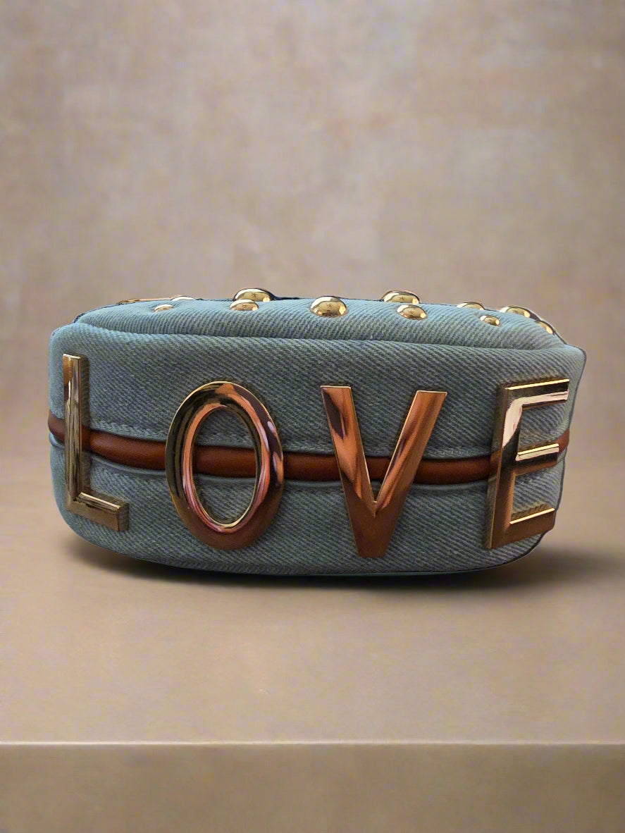 Denim clutch bag with 'LOVE' letters on a beige background