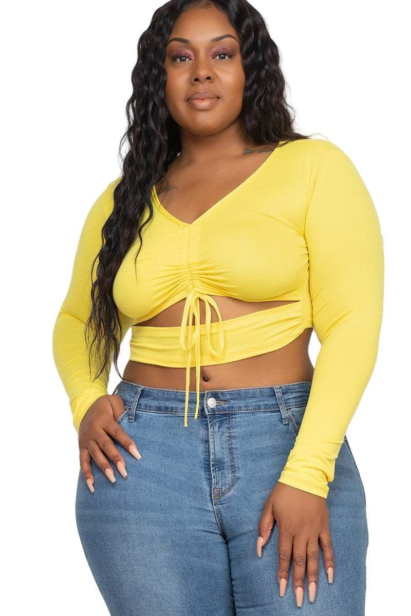 plus-size women wearing a yellow long-sleeve crop top and blue jeans on a white background