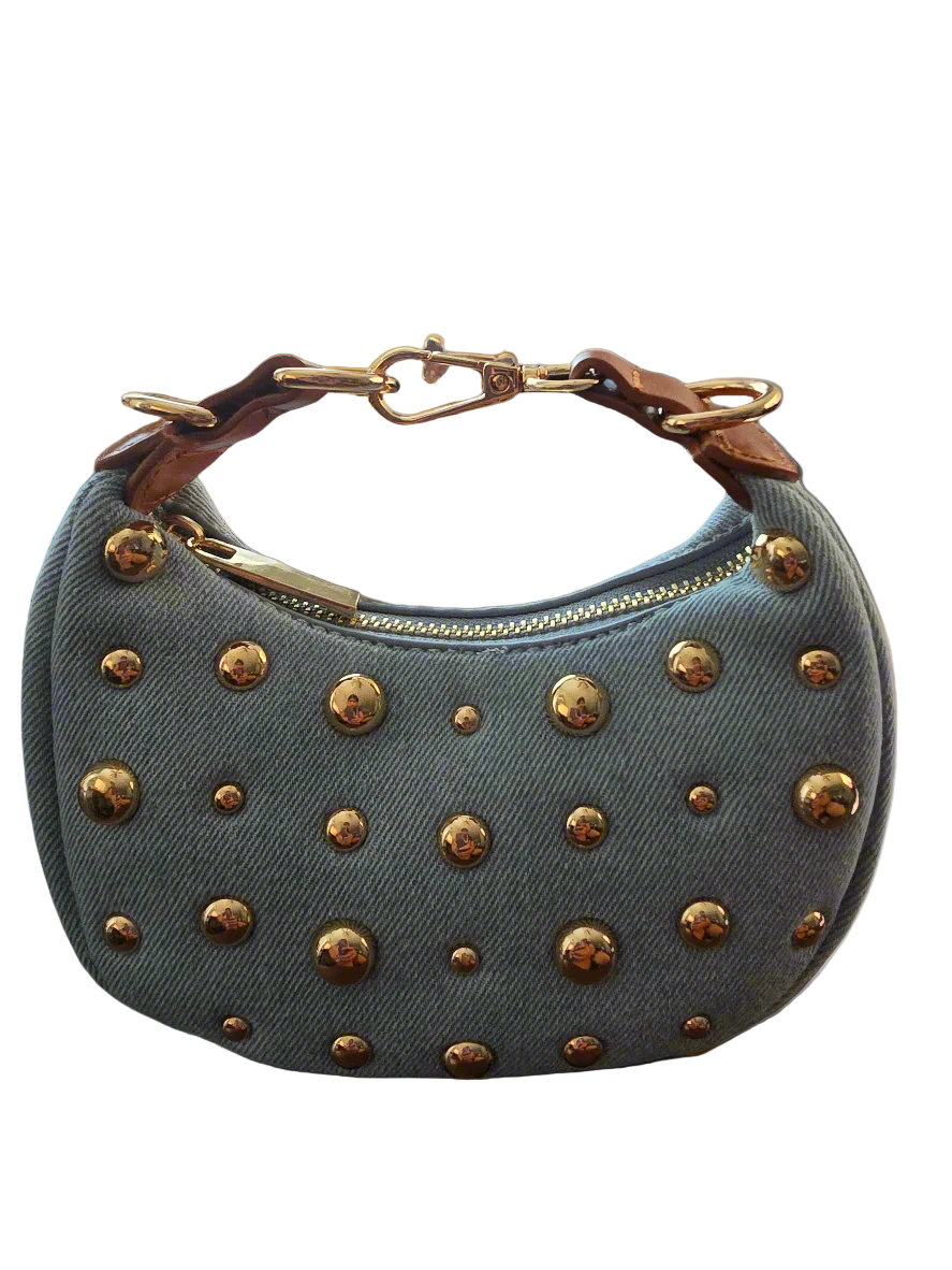Blue denim handbag with gold studs on a white background