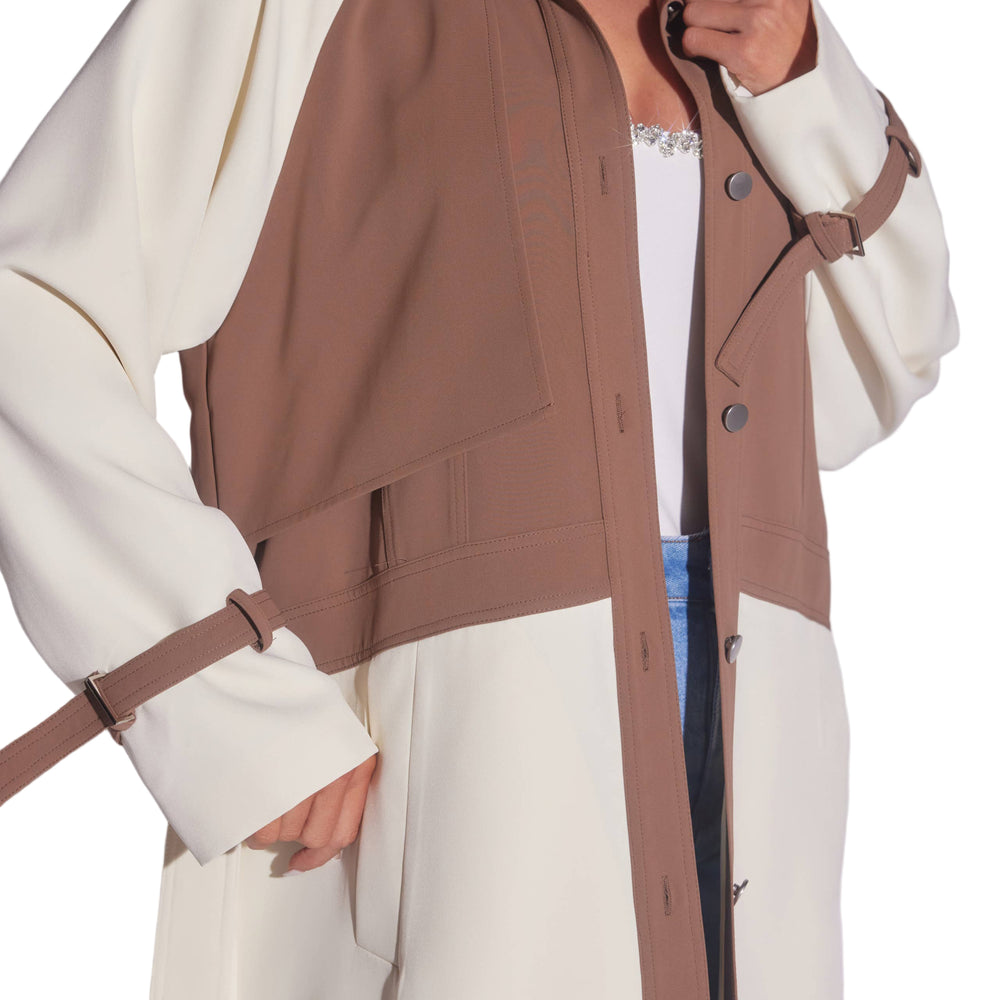 Person wearing a brown and white trench coat with a plain background