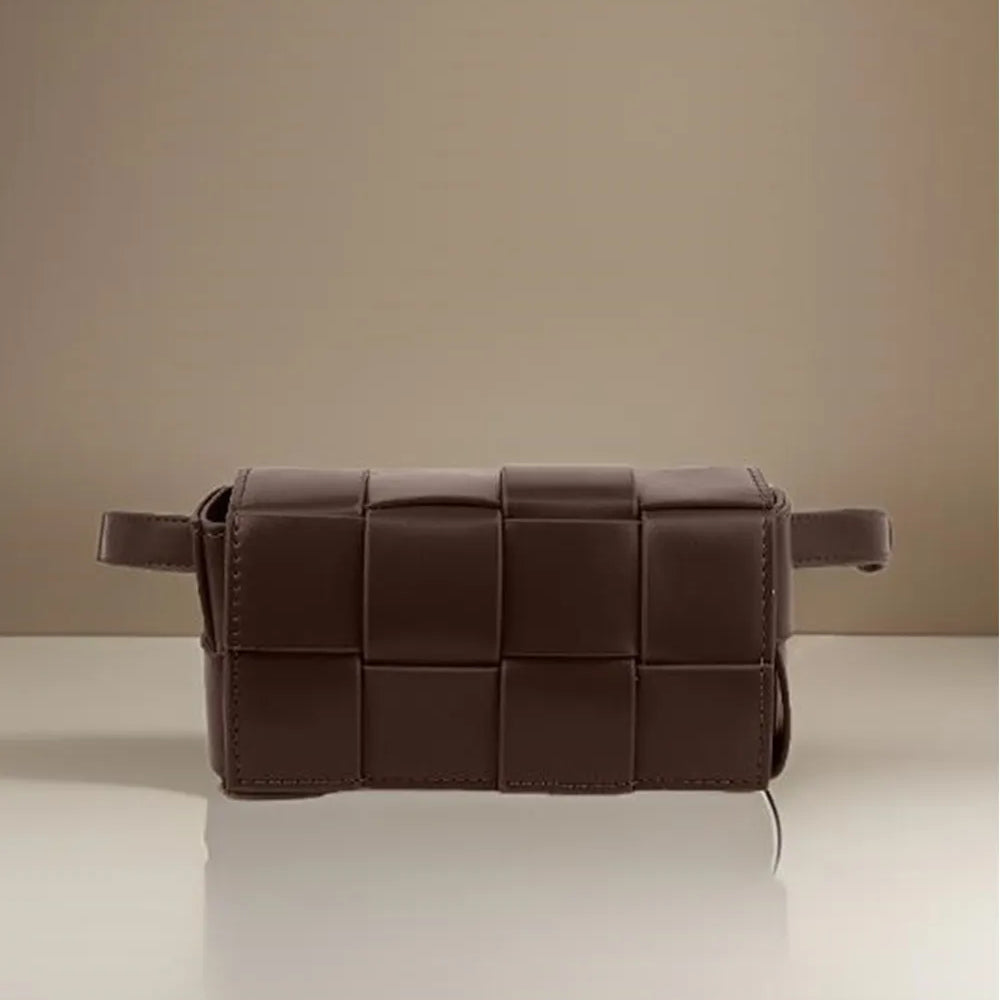 Brown woven leather bag on a reflective surface with a beige background