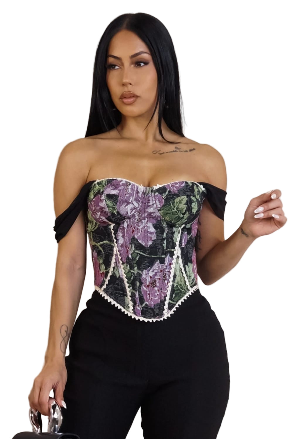 Woman wearing a strapless top with floral design and black pants against a white background
