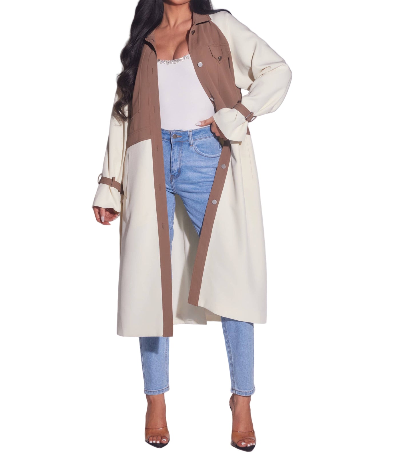 Woman wearing a long beige coat with brown accents on a plain background