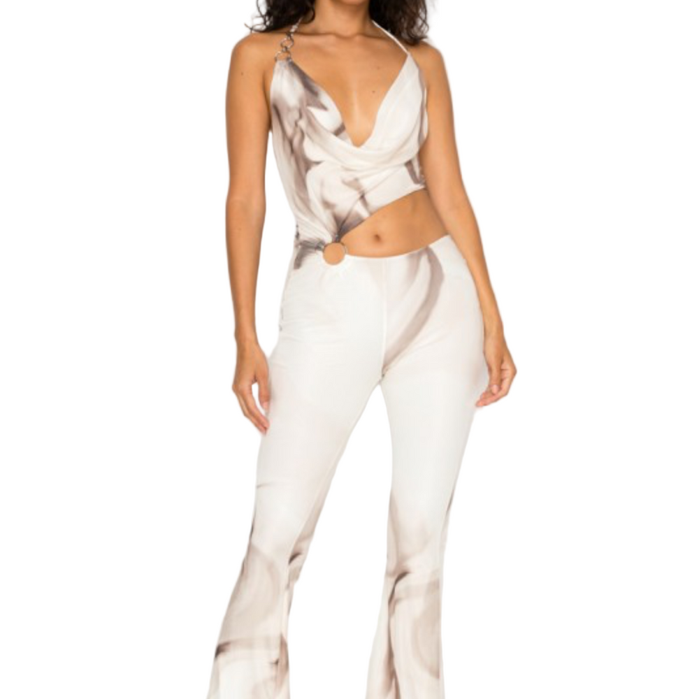 Woman wearing a white abstract print jumpsuit.